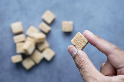 holding a brown sugar cube top view .