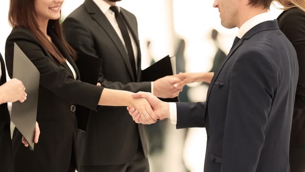 close-up of business partners shaking hands after signing of the contract against the background of the office