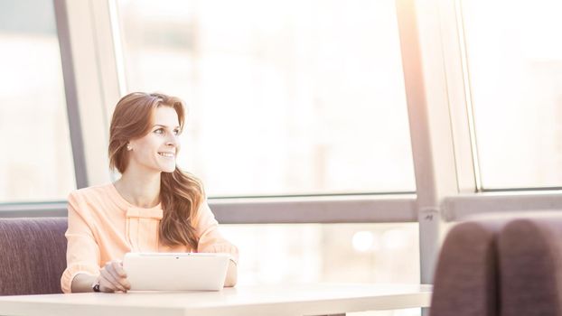 business woman with digital tablet sitting at Desk in the spacious office. the photo has a empty space for your text