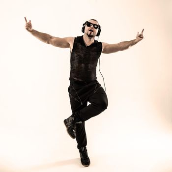 rapper with headphones takes breakdancing. photo on a white background and has an empty space for your text