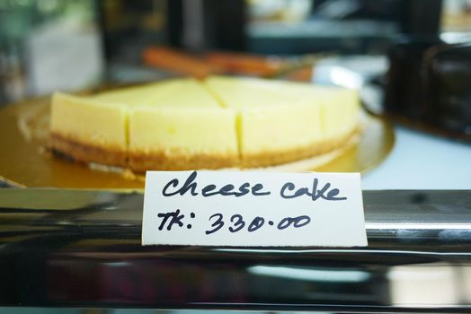 displaying slice of cheese cake at local store .