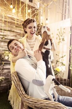 happy couple playing with his beloved dog in the living room