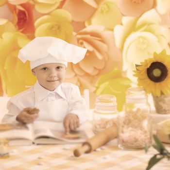 happy little boy with book chef preparing Breakfast in the kit