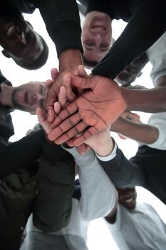 bottom view. a group of diverse young people joining their hands together . the concept of unity