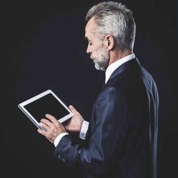 businessman with digital tablet on black background. the photo has a empty space for your text