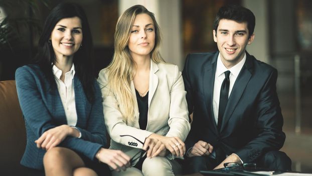 Professional business team sitting on the couch in the lobby of a modern office