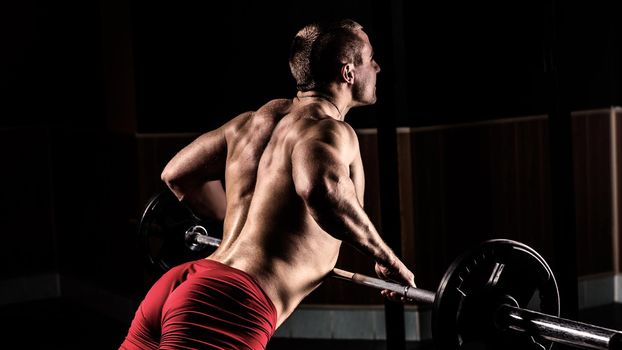 Beautiful Bodybuilder is engaged in a simulator in a modern gym