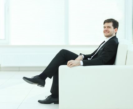 successful businessman sitting in a chair on blurred background office.photo with copy space