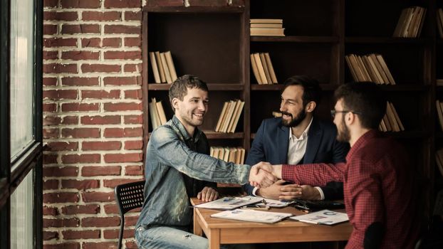 reliable business partners shake hands after discussing the contract for the work space in the office.the photo has a empty space for your text
