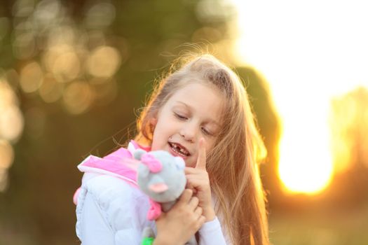 little girl hugging a favorite stuffed animal - a cat for a walk in the Park on a Sunny day.the photo has a empty space for your text