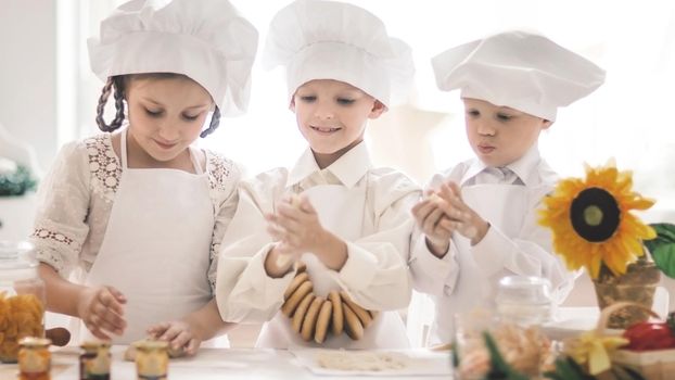 Happy little children in the shape of a chef to prepare tasty dishes in the kitchen