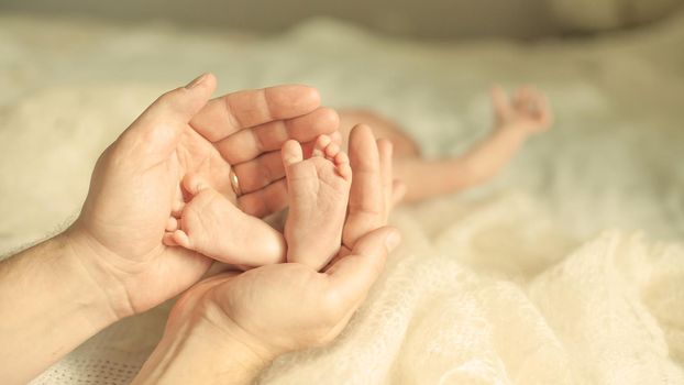 happy mother hugging the legs of a newborn baby.the photo has a empty space for your text
