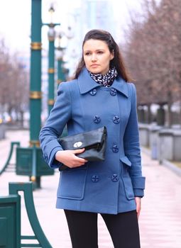 Beautiful girl walking down the street a clutch in her hands