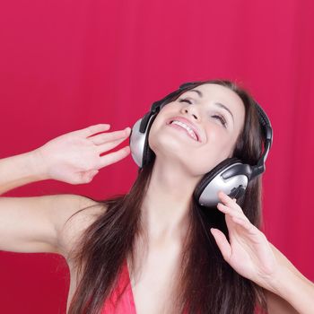 cheerful young woman listening to music through headphones .photo with copy space