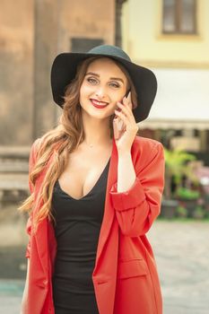 Young pretty woman is talking by the mobile phone wearing hat and smiling.