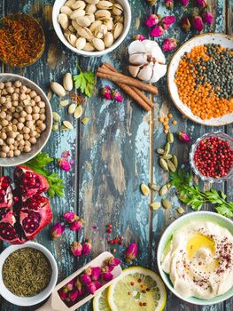 Arab ingredients for middle eastern food. Arabic cuisine ingredients. Background. Hummus, chickpea, lentils, rose buds, spices, pomegranate, pistachios. Halal food making. Space for text. Top view