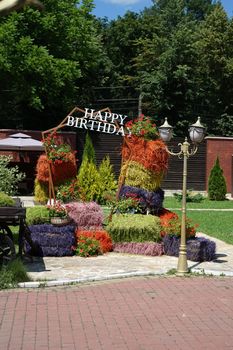 Happy birthday photo area made of natural hay bales painted in different colors.