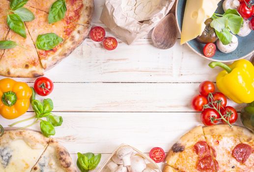Pizza with assorted toppings and ingredients background. Space for text. Pizza, flour, cheese, tomatoes, basil, pepperoni, mushrooms and rolling pin over white wooden background. Top view. Food frame