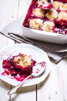 Homemade cherry cobbler pie with flaky crust, ice cream, vintage spoon, sieve for flour. Top view on the white wooden table.