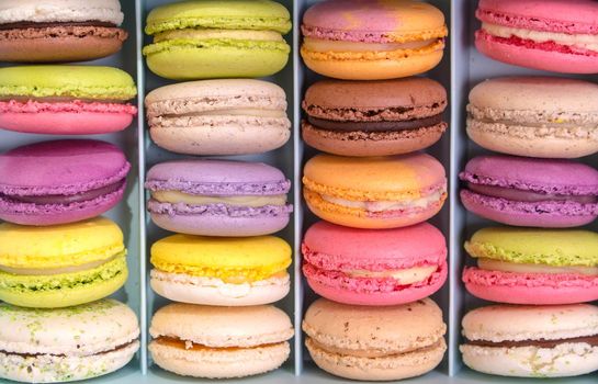 Set of different french cookies macaroons macaroons in a paper box. Top view. Closeup. Coffee, chocolate, vanilla, lemon, rapsberry, strawberry, pistachio, violet, rose, orange tastes macaroons