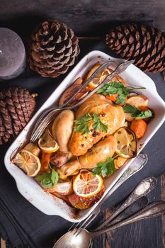 Roasted chicken. Christmas food. Rustic celebration table with roasted chicken, vegetables, apples, decorated with candles, vintage cutlery. Christmas/Thanksgiving dinner. Festive dinner. Top view