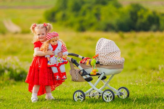 a girl rolls her doll on a toy stroller