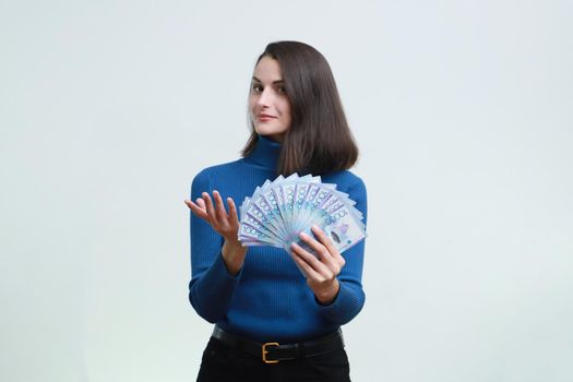 Image of a young woman with big tenge money on a white background.