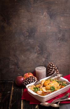 Roasted chicken. Christmas food background. Rustic celebration table with roasted chicken, vegetables, apples, decorated with candles, vintage cutlery. Christmas/Thanksgiving dinner. Space for text