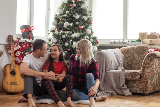 Christmas family. Happy mom, dad and little daughter. Enjoyng love hugs, holidays people. Togetherness concept.