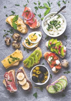 Assorted healthy sandwiches set background. Sandwich bar or buffet. Ciabatta sandwiches with dips, fish, cheese, meat, vegetables, fruits. Top view. Making sandwiches concept. Lunch time snacks