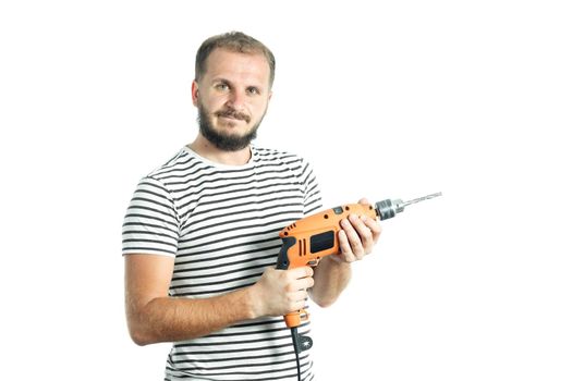 A resolute bearded man in a striped T-shirt, holds a power tool - electric drill in his hands. Isolated on white background.