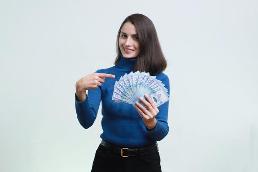 Sly girl holds a lot of tenge money in her hands.