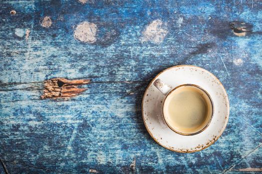 Cup of fresh hot coffee on old rustic blue wooden table. Vintage background. Space for text. Morning coffee. Warm black coffee. Espresso, white cup. Top view. Close up. Freshly made espresso