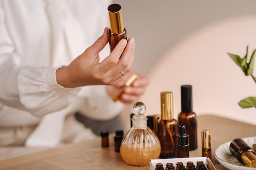 Close-up of female hands holding a bottle of essential oil, Aromatherapy.