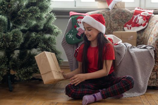 Little cute girl looking inside of glowing Christmas present box.