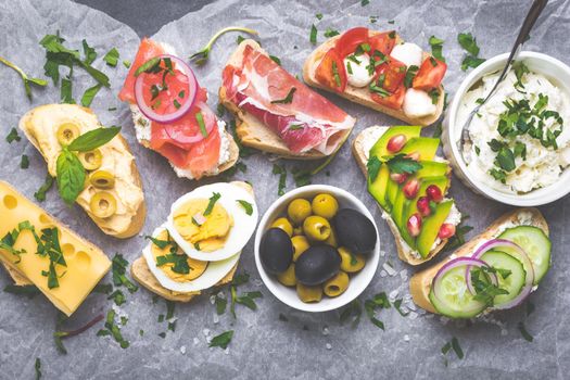 Assorted healthy sandwiches set background. Sandwich bar or buffet. Ciabatta sandwiches with dips, fish, cheese, meat, vegetables. Top view. Making sandwiches concept. Lunch time snacks. From above