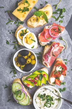 Assorted healthy sandwiches set background. Sandwich bar or buffet. Ciabatta sandwiches with dips, fish, cheese, meat, vegetables. Top view. Making sandwiches concept. Lunch time snacks. From above