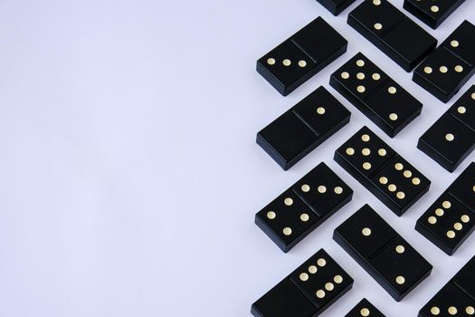 Black old, vintage dominoes on white background. The concept of the game dominoes. Selective focus. Copy space. Pastime. Table games.
