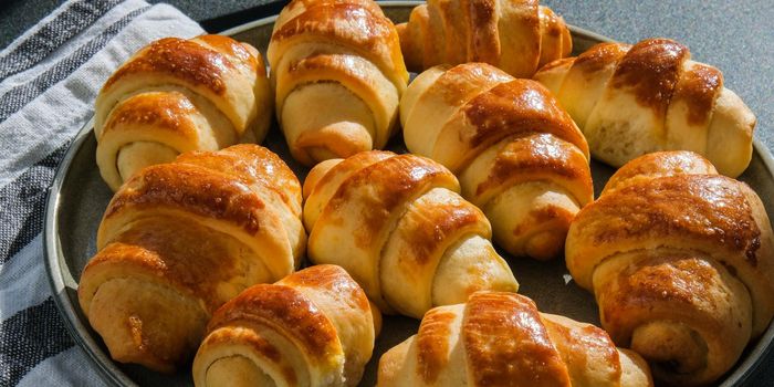 Homemade delicious croissants on a dessert gray plate on kitchen towel. Tasty homemade buttery croissants cake. Home bakery.