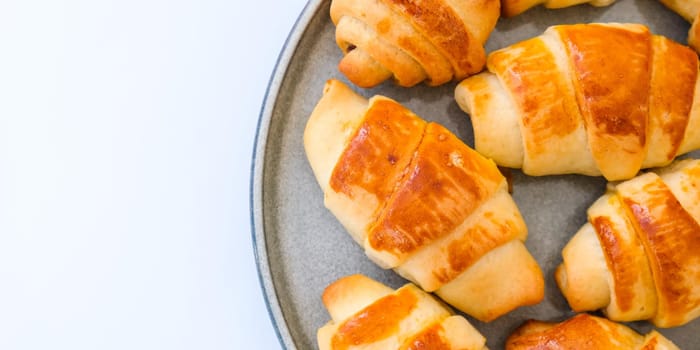 Homemade delicious croissants on a dessert gray plate. Tasty homemade buttery croissants cake. Home bakery. Frances national food. Morning breakfast