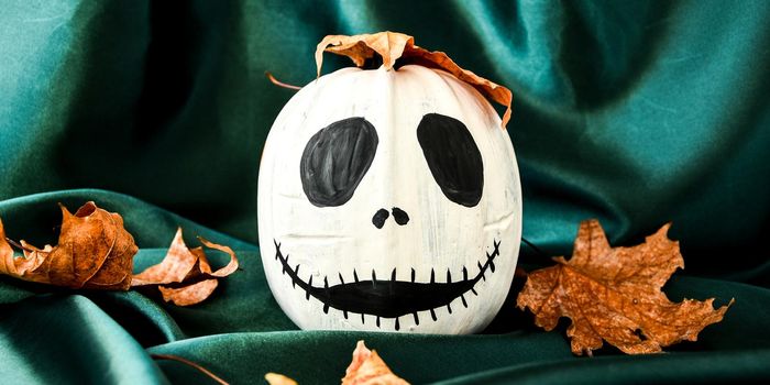Halloween background with painted face pumpkins and autumn leaves. Diy. Do it yourself. Halloween decorations, black and white pumpkins, bats, ghosts. Halloween party greeting card