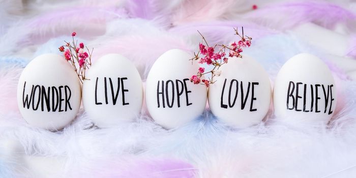 Easter DIY. Do it yourself. Trendy Easter Eggs Composition. Egg name settings. Words drawn with pen. High Angle View Of Shells On Table. Pastel colors. Love Live Believe Wonder Hope