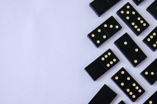 Black old, vintage dominoes on white background. The concept of the game dominoes. Selective focus. Copy space. Pastime. Table games.