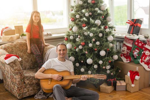 Happy family with guitar in motorhome on Christmas eve.