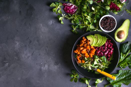 Fresh quinoa organic vegetables salad in bowl on concrete rustic background. Quinoa superfood concept. Clean healthy detox eating. Vegan/vegetarian food. Making healthy salad. Space for text. Top view