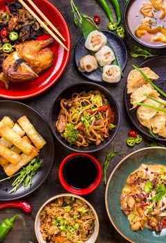 Assorted Chinese food set. Chinese noodles, fried rice, dumplings, peking duck, dim sum, spring rolls. Famous Chinese cuisine dishes on table. Top view. Chinese restaurant concept. Asian style banquet