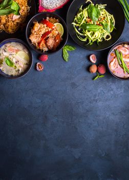 Thai food background. Dishes of thai cuisine. Tom yum, tom kha gai, pad thai noodles, thai fried rice with pork and vegetables khao phat mu, green papaya salad som tam, thai fruits. Space for text