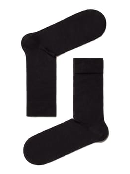 Black mans socks for clothing laying isolated on white background.