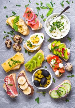 Assorted healthy sandwiches set background. Sandwich bar or buffet. Ciabatta sandwiches with dips, fish, cheese, meat, vegetables, fruits. Top view. Making sandwiches concept. Lunch time snacks