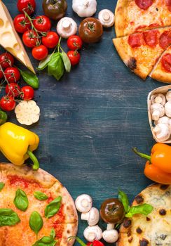 Pizza with assorted toppings and ingredients background. Space for text. Pizza, flour, cheese, tomatoes, basil, pepperoni, mushrooms and rolling pin over wooden background. Top view. Food frame